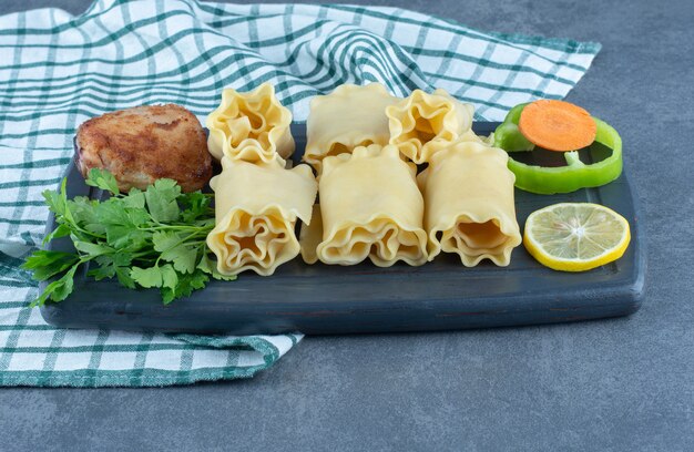 Petits pains bouillis et poulet rôti sur planche sombre.