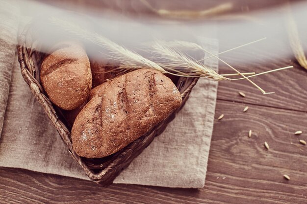 Petits pains fraîchement chauds dans un panier en forme de cœur. Photo en gros plan de produits de pain fraîchement cuits.