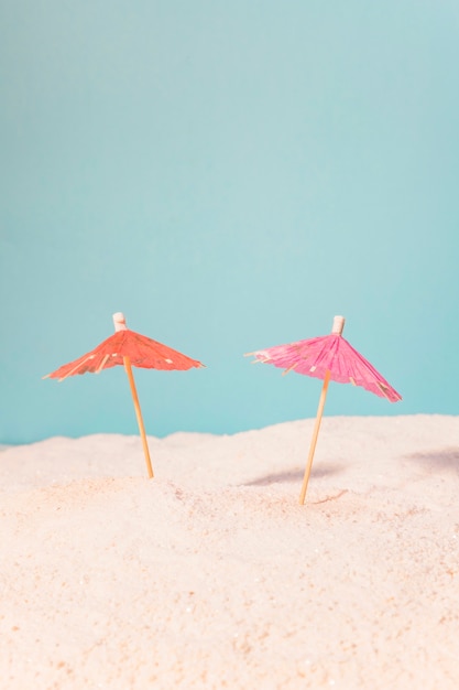 Photo gratuite petits parapluies pour des boissons dans le sable