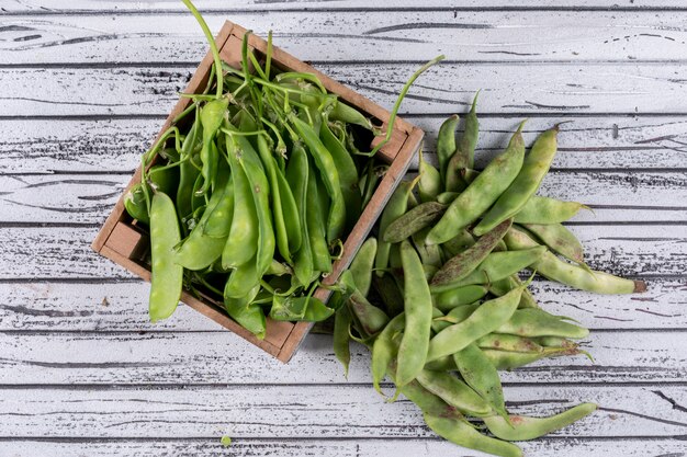 Petits pois dans une boîte en bois et à part