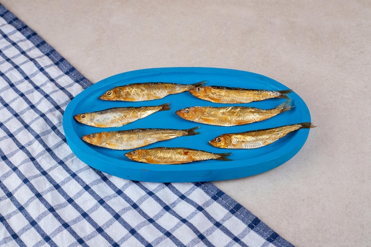 Photo gratuit petits poissons séchés sur plaque bleue