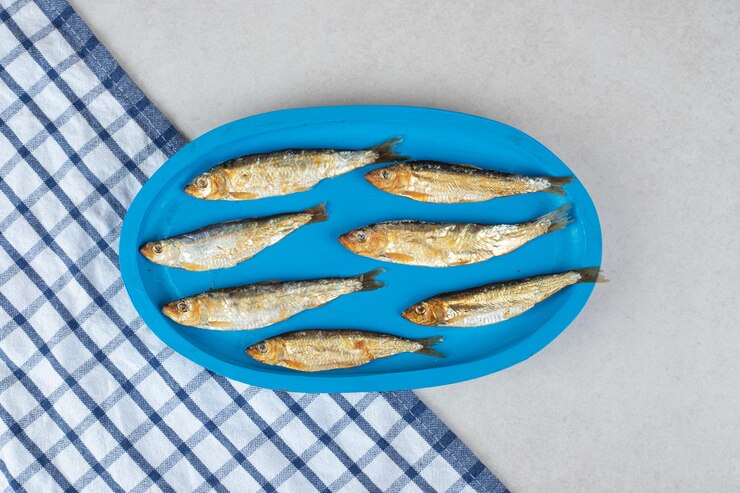 Photo gratuit petits poissons séchés sur plaque bleue