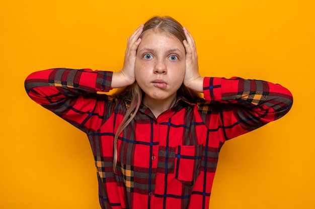 Peur attrapé la tête belle petite fille portant une chemise rouge