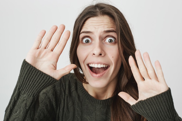 Peur de jeune femme levant la main en se rendant, crier embusqué