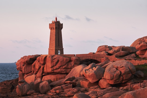 Phare brun sur une falaise rocheuse près d'un plan d'eau