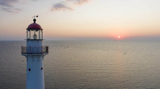 Phare sur l'île de Kihnu en Estonie pendant un beau coucher de soleil