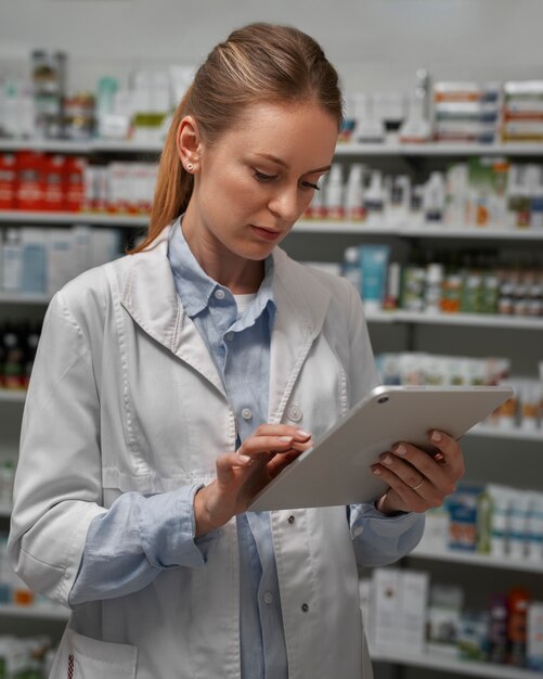 Pharmacien féminin avec table vérifiant le stock en pharmacie