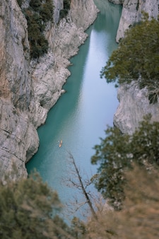 Photo aérienne d'un kayak dans une rivière entre les montagnes