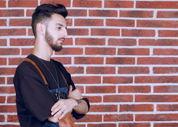 Photo de beau coiffeur debout bras croisés. Photo de haute qualité