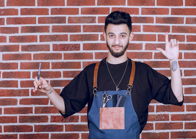 Photo de beau coiffeur tenant des ciseaux. Photo de haute qualité