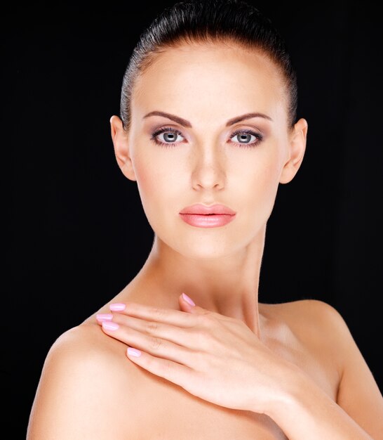 Photo d'un beau visage de la jolie femme adulte avec une peau fraîche - sur fond noir