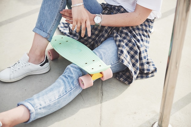 Une photo d'une belle fille avec de beaux cheveux tient une planche à roulettes sur une longue planche