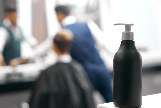 Photo d'une bouteille en plastique noir avec distributeur comprenant un produit de soin des cheveux