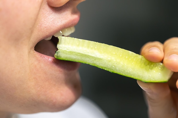 Photo gratuite une photo détaillée d'une femme mangeant du concombre frais