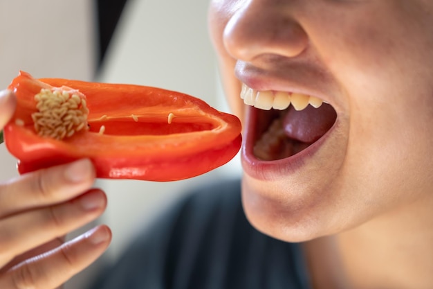 Photo gratuite une photo détaillée d'une femme mordant du poivre rouge