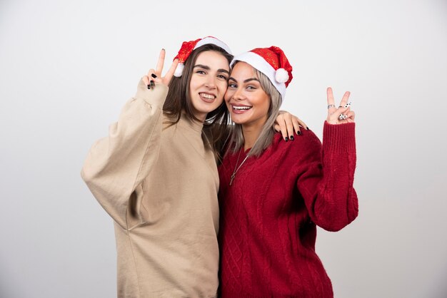 Photo de deux amies souriantes debout et s'embrassant.