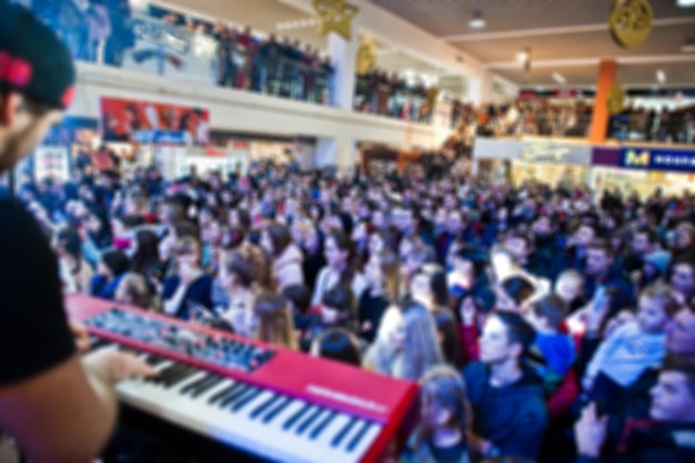 Photo estompée salle de concert bondée avec des lumières de scène avec des gens à la performance rock