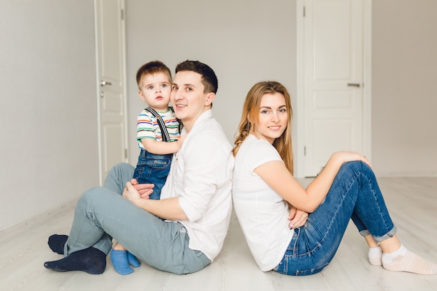 Photo de famille de deux jeunes parents jouant avec leur garçon