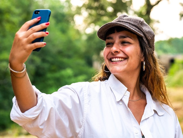 Photo d'une femme brune prenant un selfie avec un beau sourire