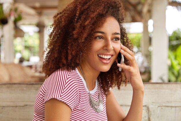 Photo d'une femme noire heureuse a les cheveux bouclés et touffus