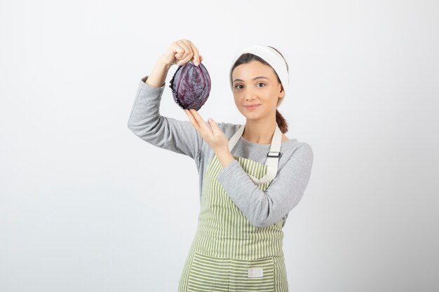 Photo de femme positive posant avec du chou violet sur blanc