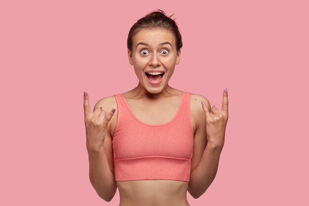 Photo d'une fille sportive cool étonnée fait un geste rock n roll