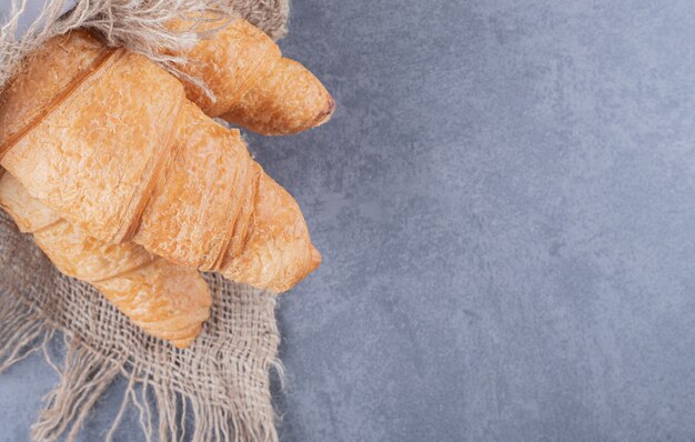 La photo en gros plan de croissants fraîchement cuits sur fond gris.