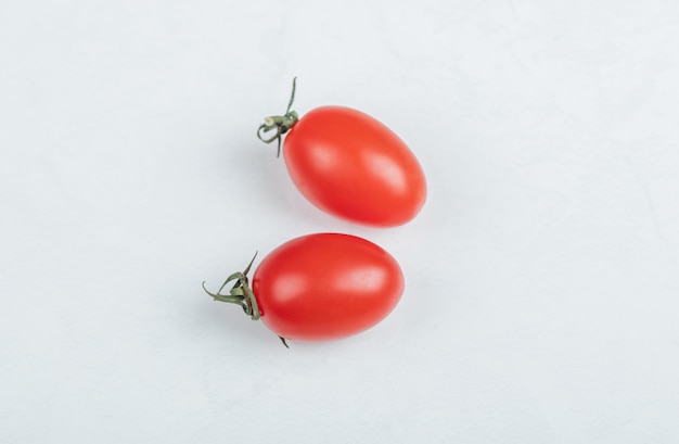 La photo en gros plan de deux tomates cerises. sur fond blanc. Photo de haute qualité