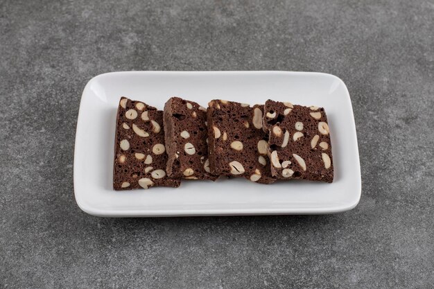 La photo en gros plan d'un gâteau au chocolat fait maison avec des cacahuètes. Tranches fraîches dans l'assiette.