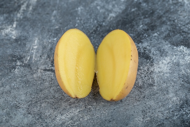 La photo en gros plan de pommes de terre coupées à moitié bio. Photo de haute qualité