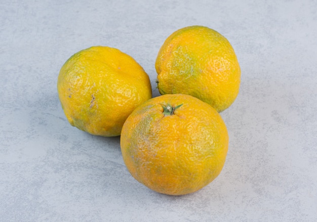 La photo en gros plan de trois mandarines fraîches.