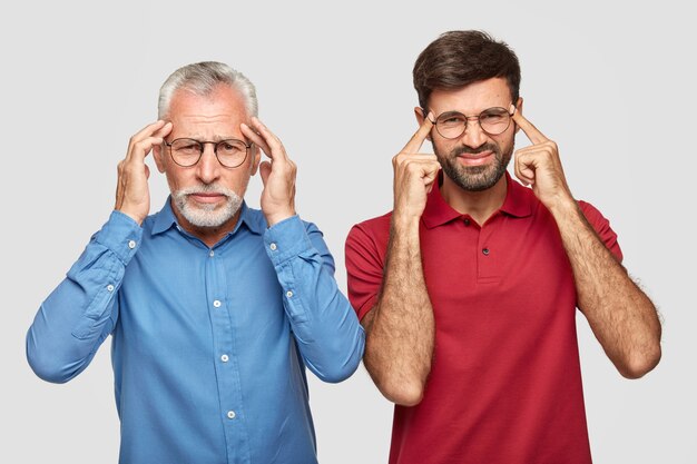 Photo d'un homme européen mature et de son assistant masculin inexpérimenté souffrent de migraine