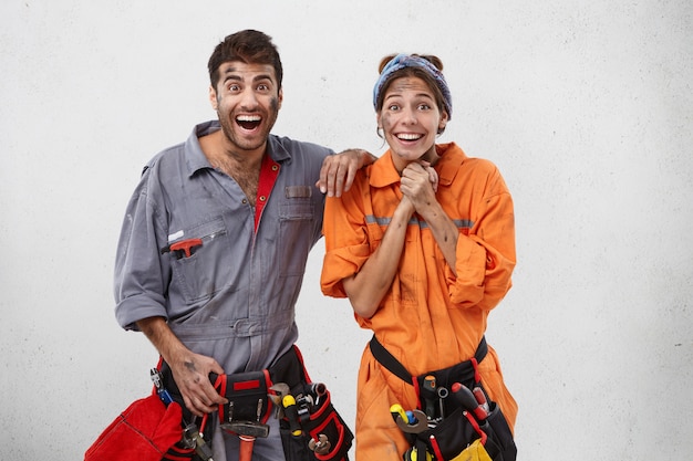 Photo intérieure de plombiers féminins et masculins émotionnels excités comme promus au travail