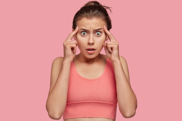 Photo d'une jeune athlète féminine surmenée et stressée garde les deux index sur les tempes