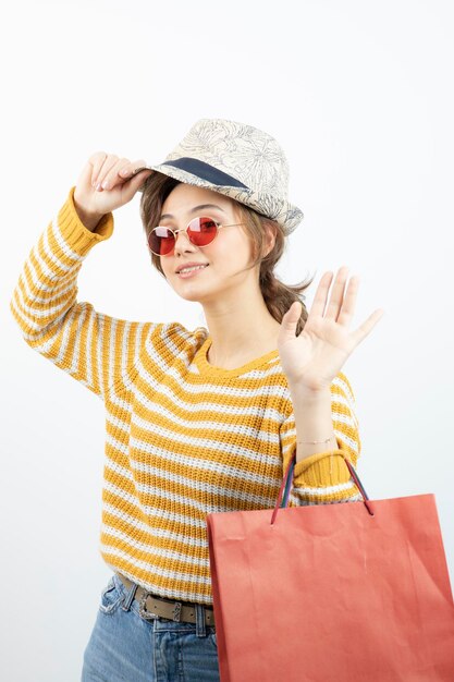 Photo de jeune femme brune à lunettes de soleil tenant un sac à provisions. Photo de haute qualité