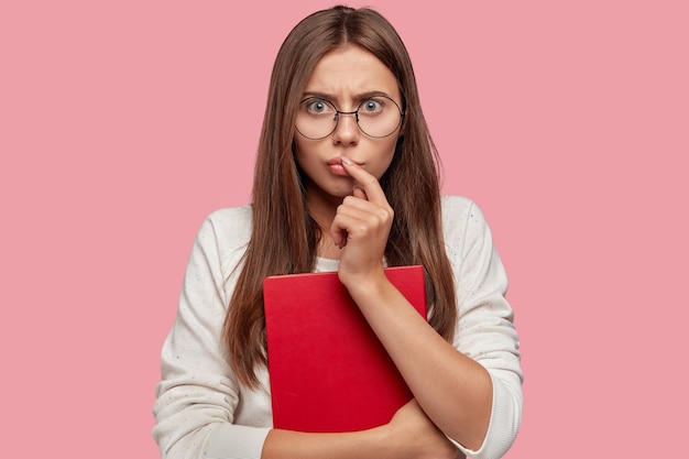 Photo de jeune femme effrayée émotive regarde avec une expression perplexe