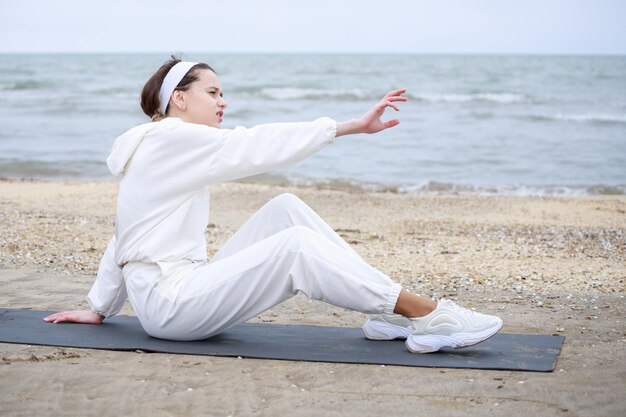 Photo de jeune femme à la plage allongée sur le tapis Photo de haute qualité