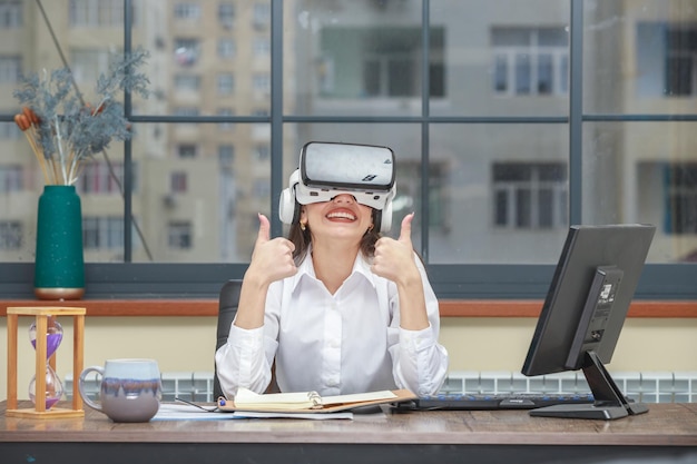 Photo d'une jeune femme portant un appareil VR et un geste du pouce vers le haut Photo de haute qualité