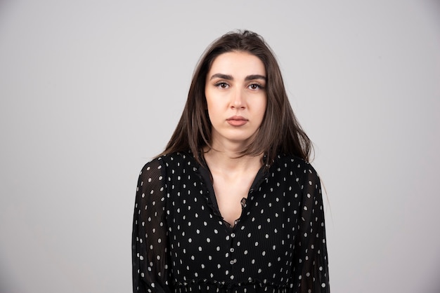 Photo de jeune femme sérieuse debout et posant.