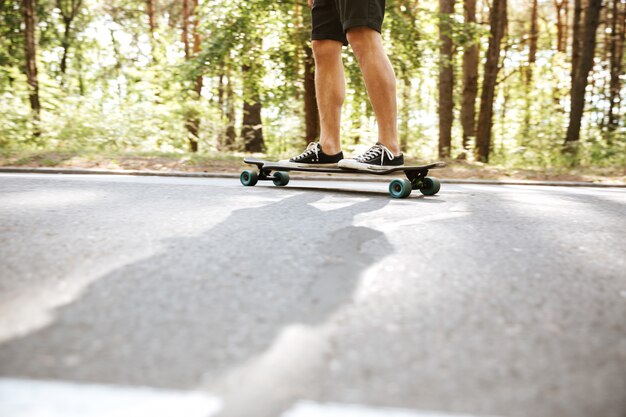 Photo de jeune homme sur la planche à roulettes à l'extérieur.