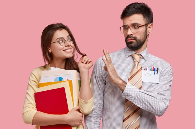 Photo de jolie femme flirte avec son jeune enseignant, porte des papiers et bloc-notes