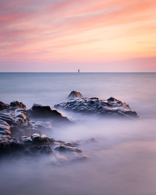 Photo de longue exposition du paysage marin à Guernesey pendant un coucher de soleil
