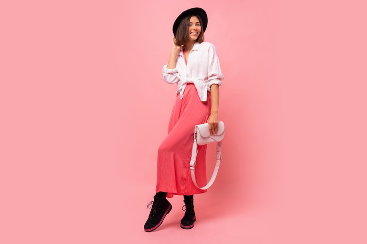 Photo gratuit photo de mode de belle femme brune en tenue de printemps posant tenant un sac blanc. longueur totale.