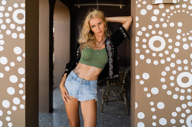 Photo De Mode Estivale D'une Femme Blonde Séduisante Avec Une Silhouette Parfaite En Haut Sexy Et Jeans Posant En Plein Air Portant Des Accessoires Boho