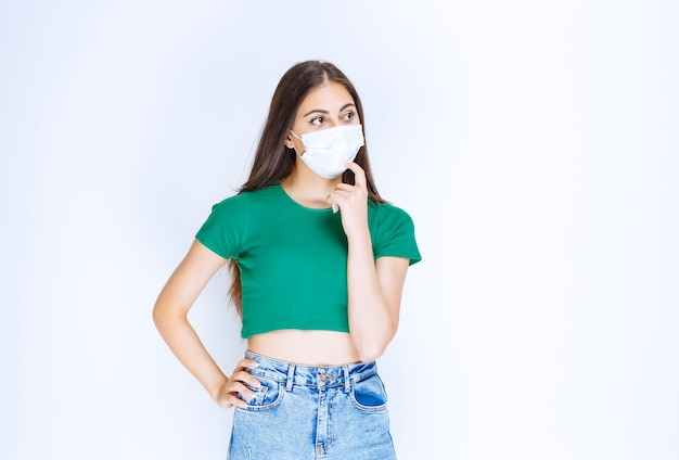 Photo D'un Modèle De Jeune Femme Debout Et Portant Un Masque Médical De Protection.