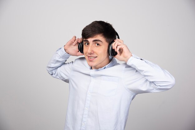 Photo d'un modèle de jeune homme écoutant de la musique dans des écouteurs sans fil