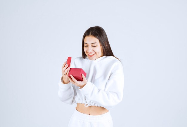 Photo d'un modèle de jolie jeune fille tenant une boîte-cadeau.