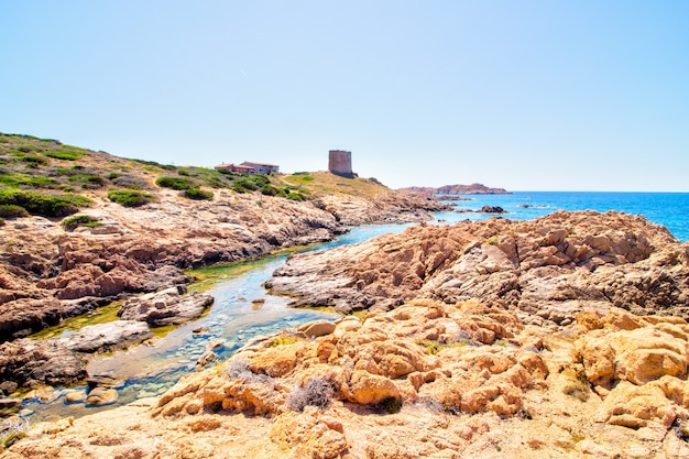 Photo gratuite photo de paysage de collines rocheuses avec château près de la mer ouverte avec un ciel bleu clair et ensoleillé