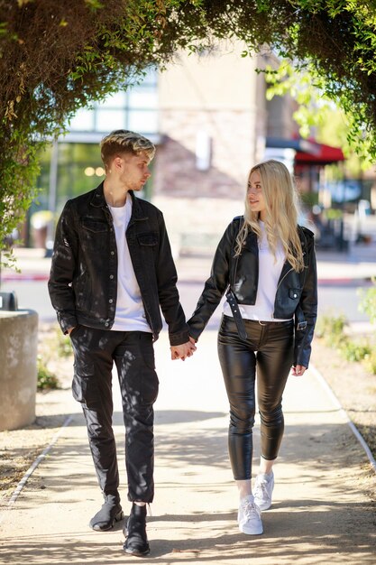 Photo pleine longueur d'un jeune couple marchant dans le parc