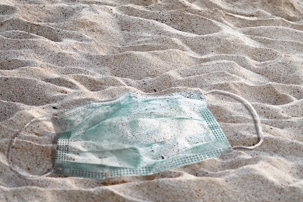 Photo de pollution des océans avec masque facial usagé sur la plage